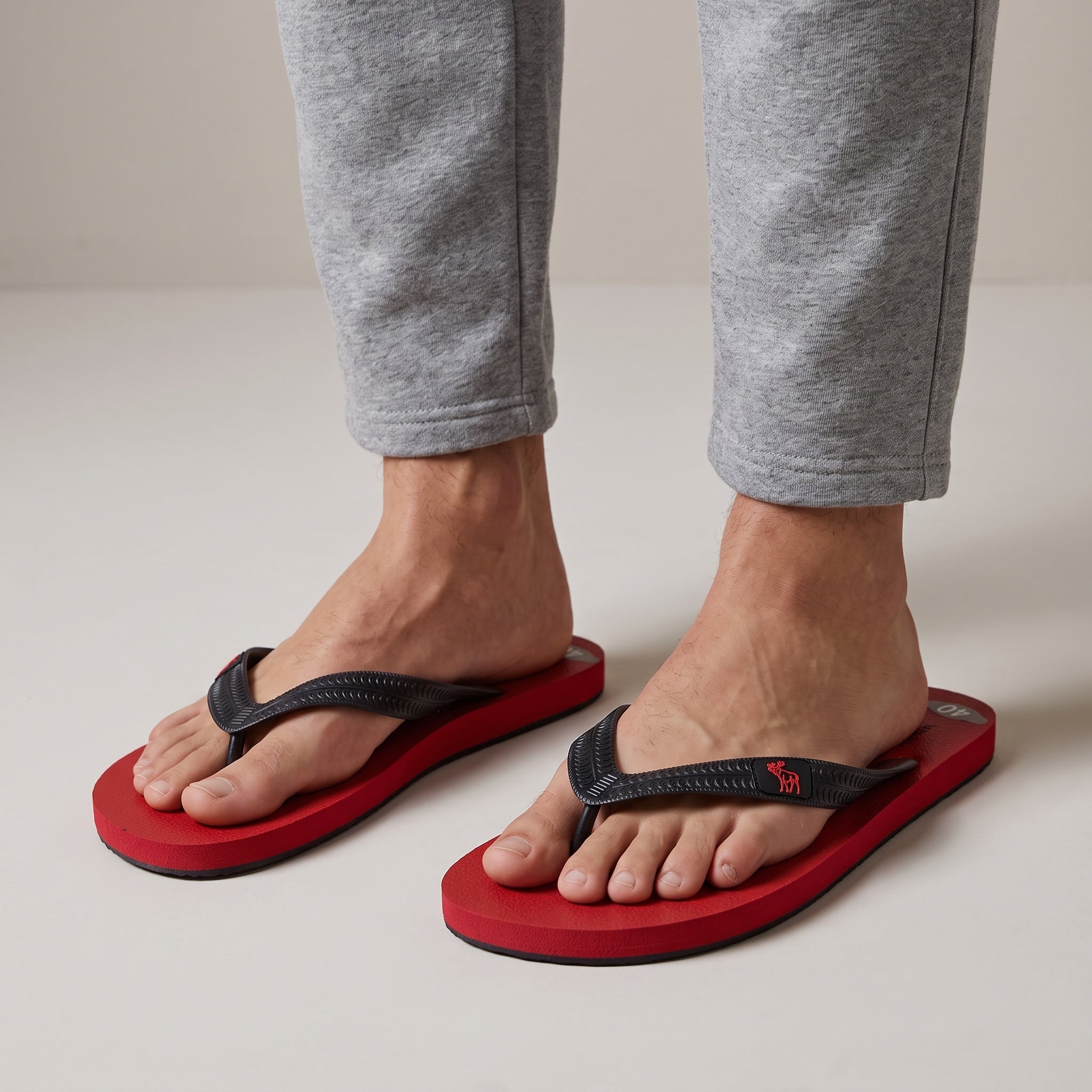 red sole flip flops with black textured straps and small red logo on strap