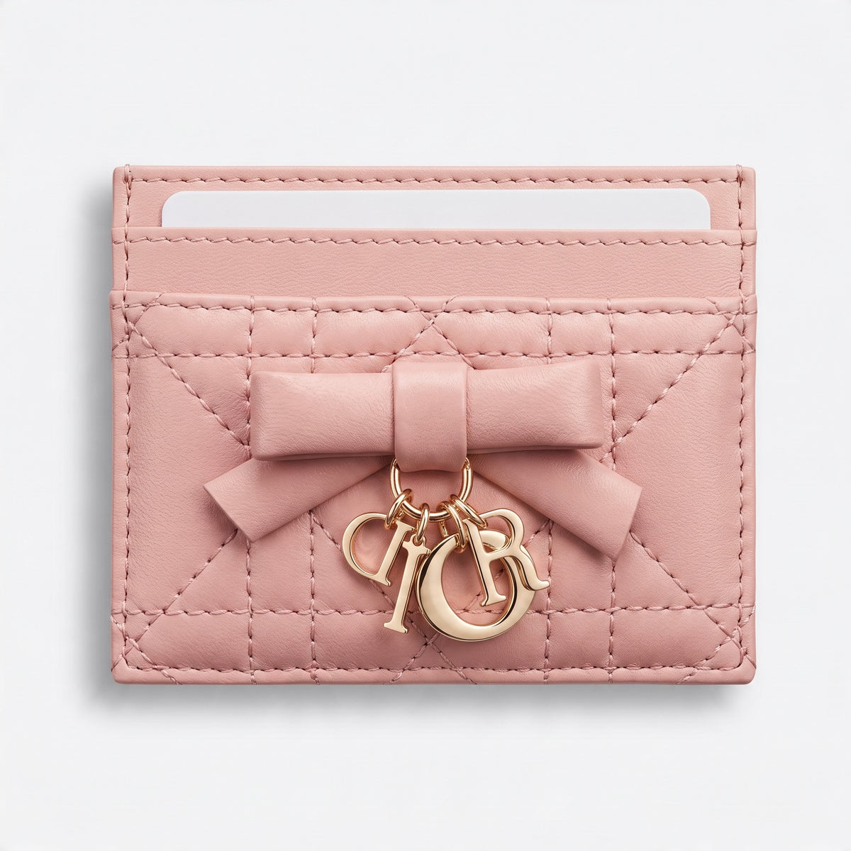 pink quilted Dior card holder with bow and gold letter charms