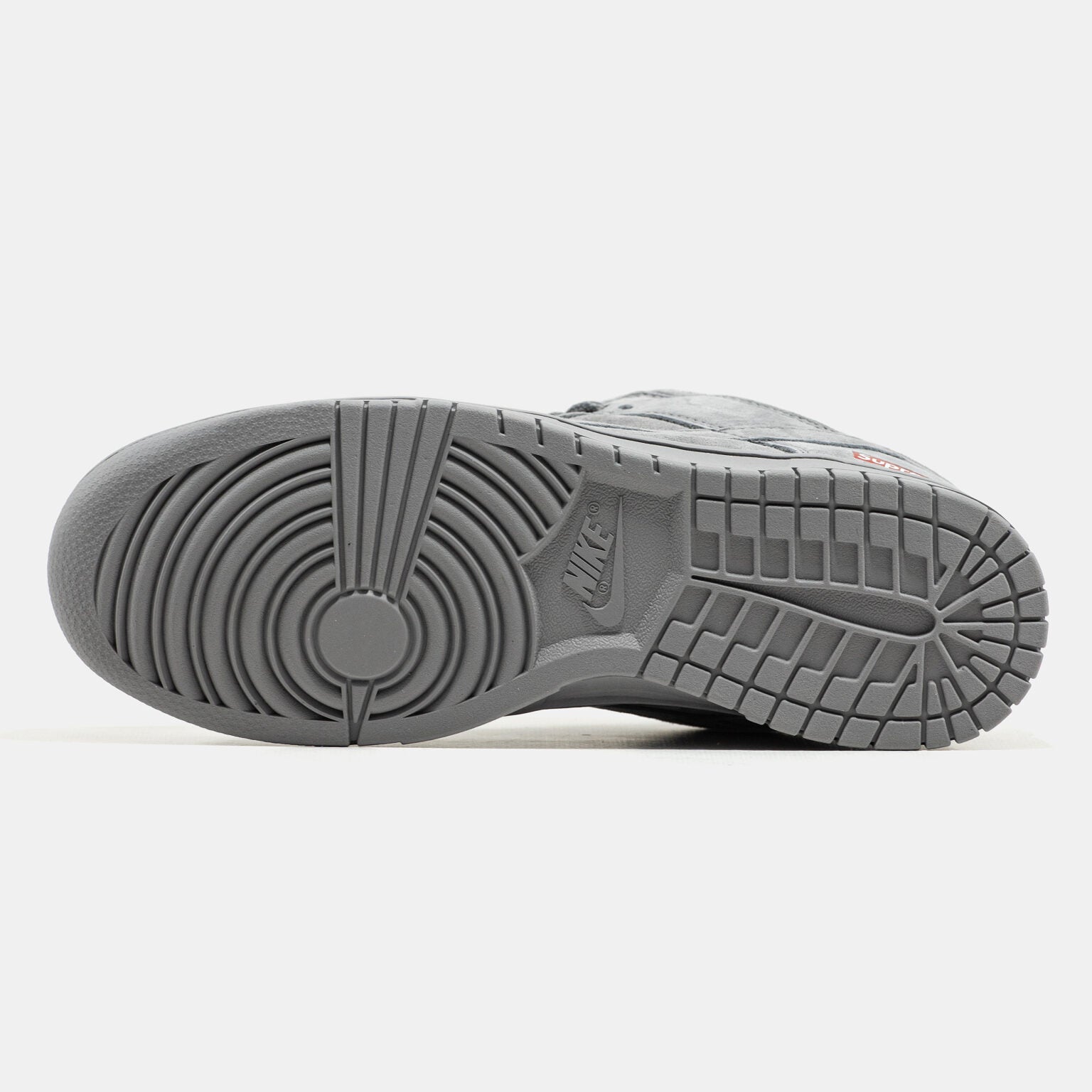 Grey Nike Dunk Low suede sneaker with small red Supreme box logo at heel
