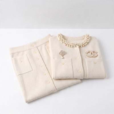 Cream cropped cardigan with pearl collar, chest pockets and decorative brooches