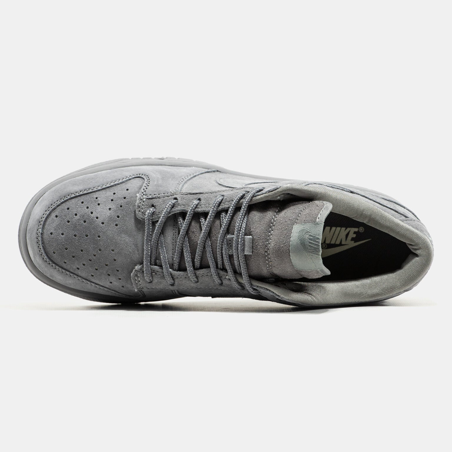 Grey Nike Dunk Low suede sneaker with small red Supreme box logo at heel