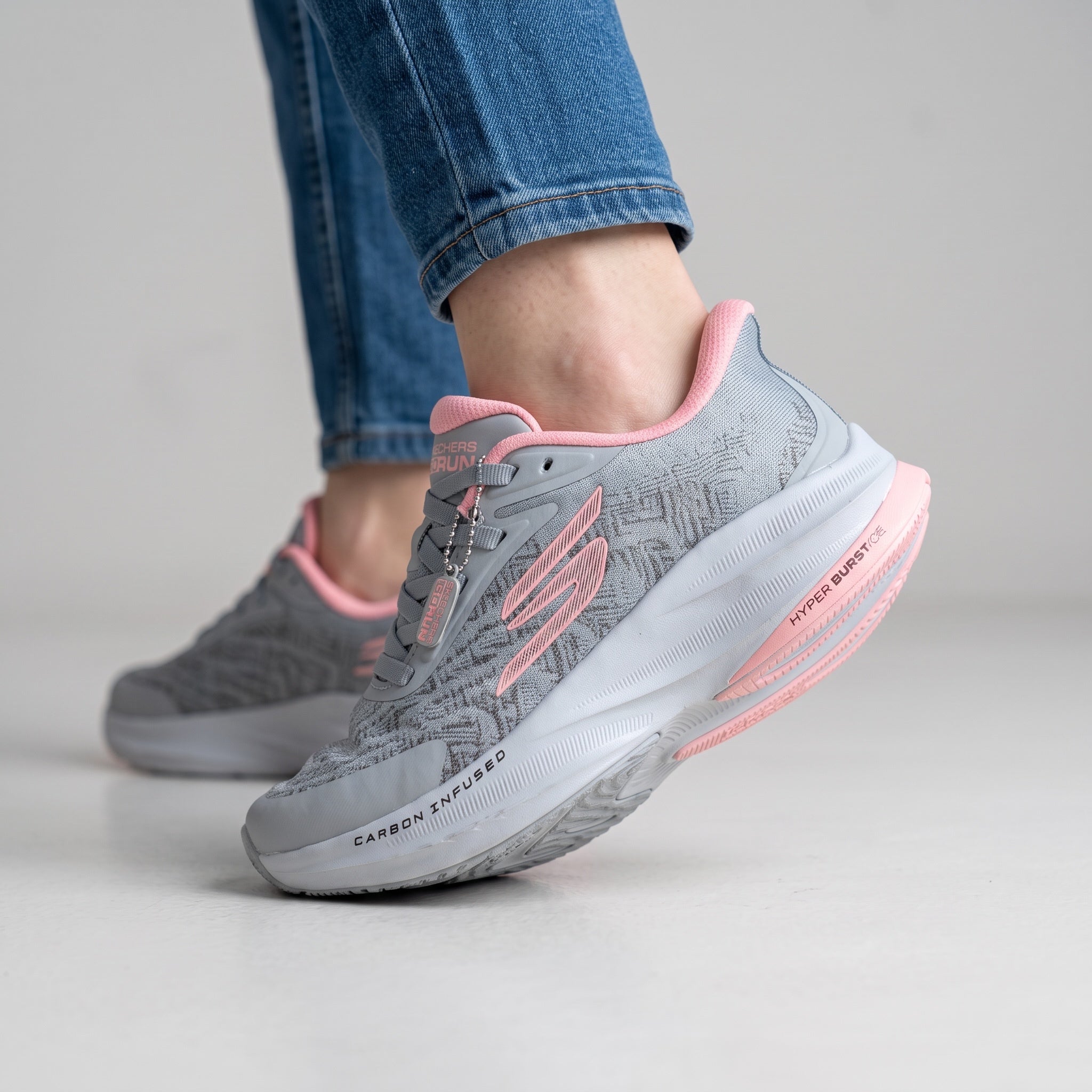 grey Skechers running sneaker with pink accents and chunky white midsole
