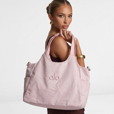 soft pink Alo Yoga tote bag with double shoulder straps and raised logo