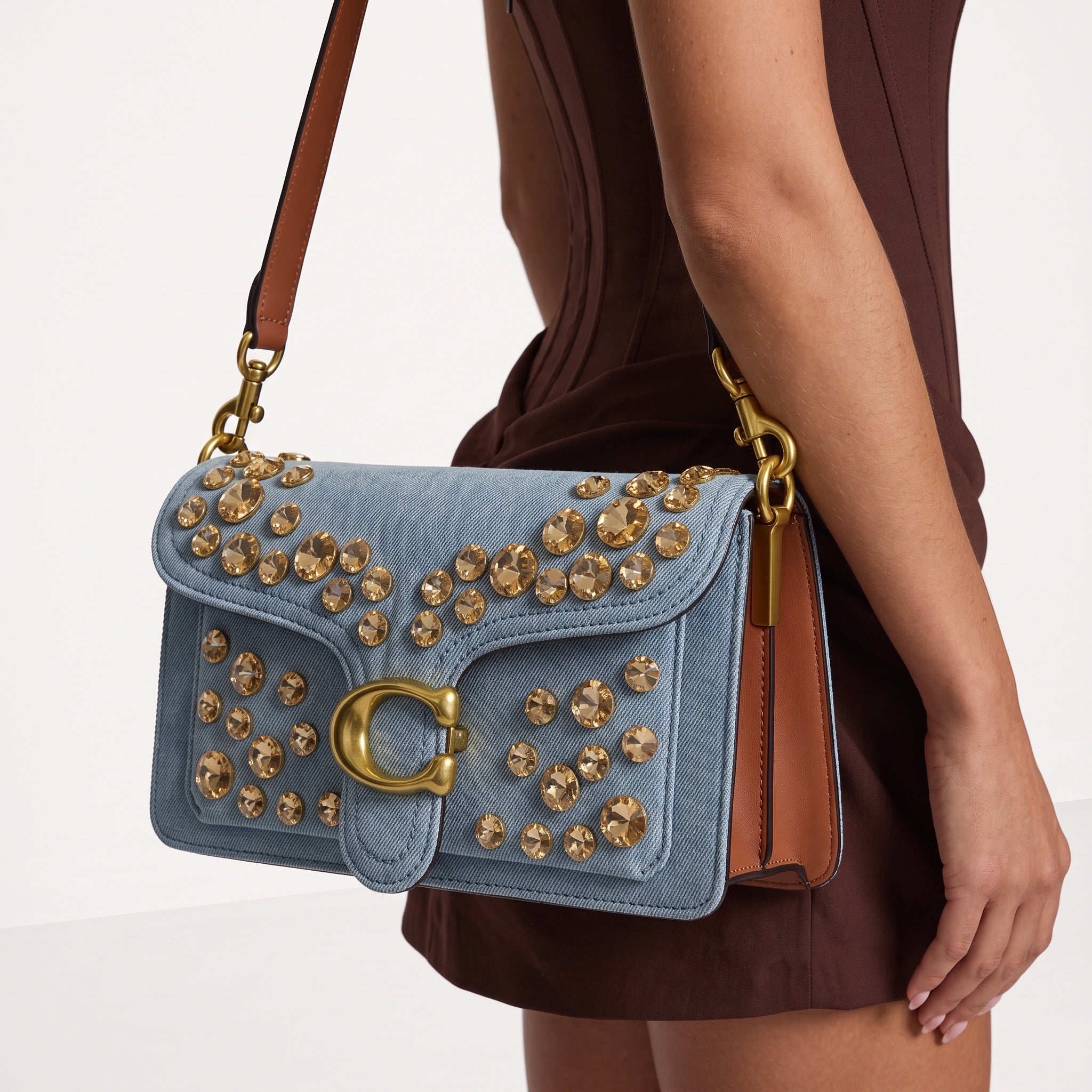 Light blue denim Coach shoulder bag with gold crystal studs and brown leather handle