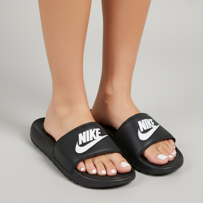 Black Nike slides with white NIKE logo on wide strap, cushioned footbed