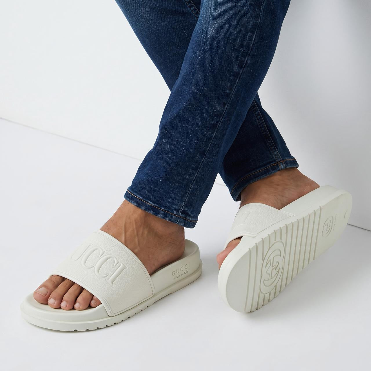 White Gucci embossed logo slide sandals with ridged sole
