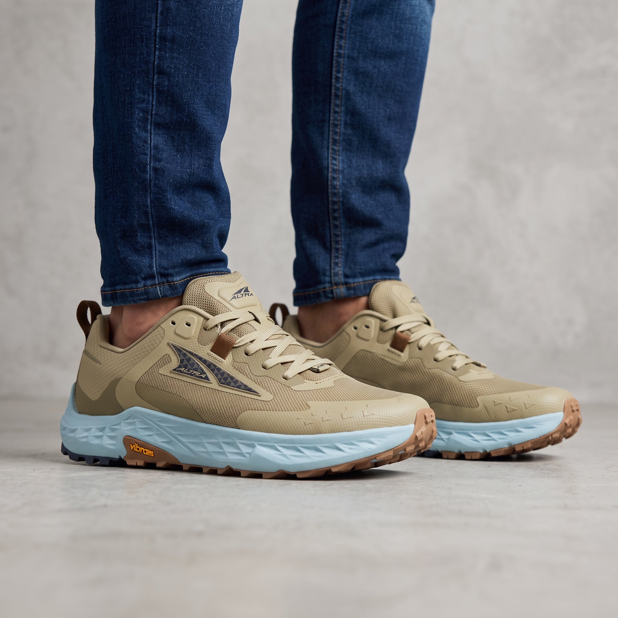 Altra tan trail running shoe with light blue midsole and Vibram sole