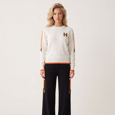 Ivory crewneck sweater with orange trim and brown H logos on chest and sleeves