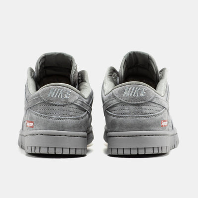 Grey Nike Dunk Low suede sneaker with small red Supreme box logo at heel