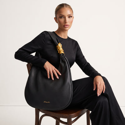 Black Schiaparelli crescent hobo shoulder bag with gold sculptural clasp
