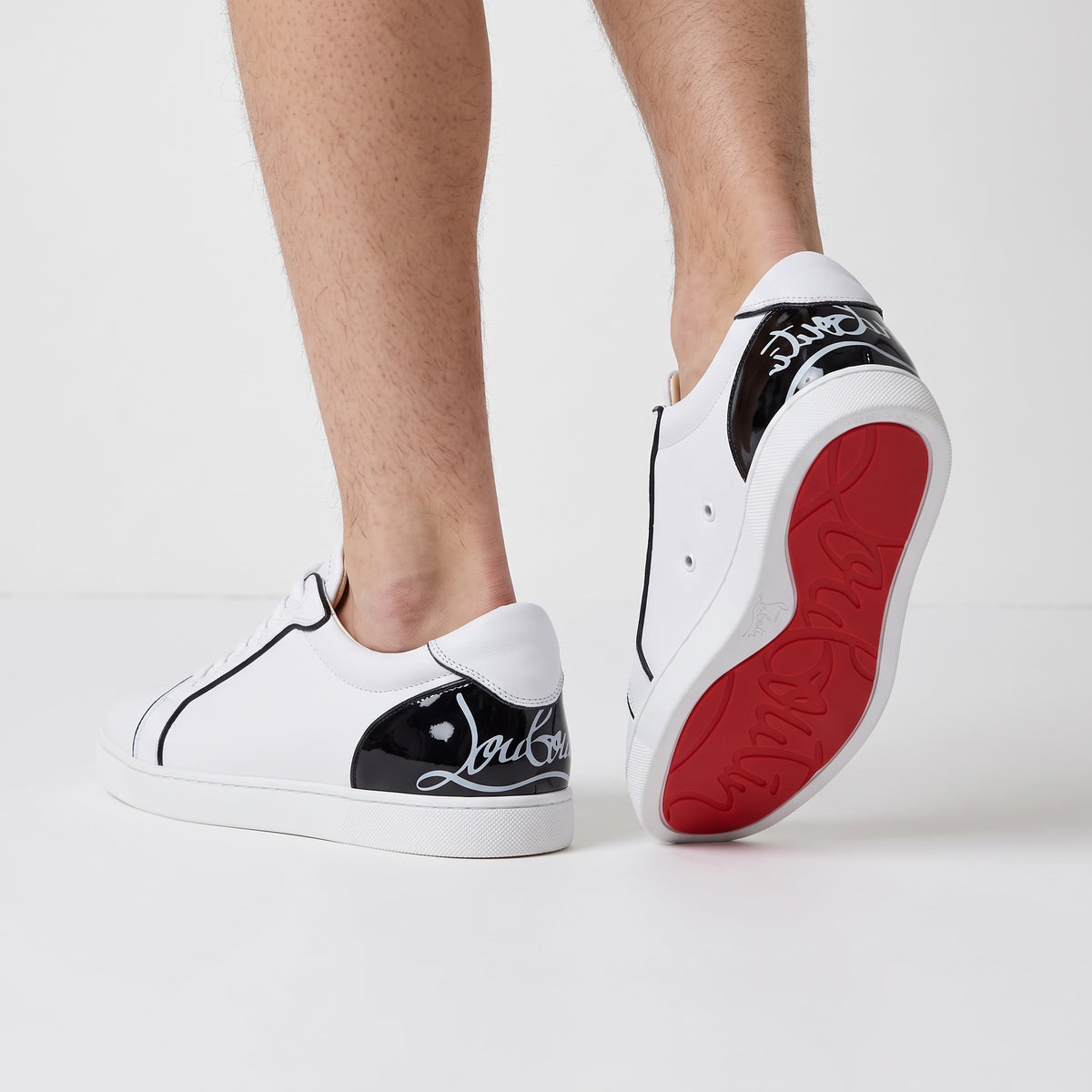 Christian Louboutin white low-top sneakers with black heel tab and red sole