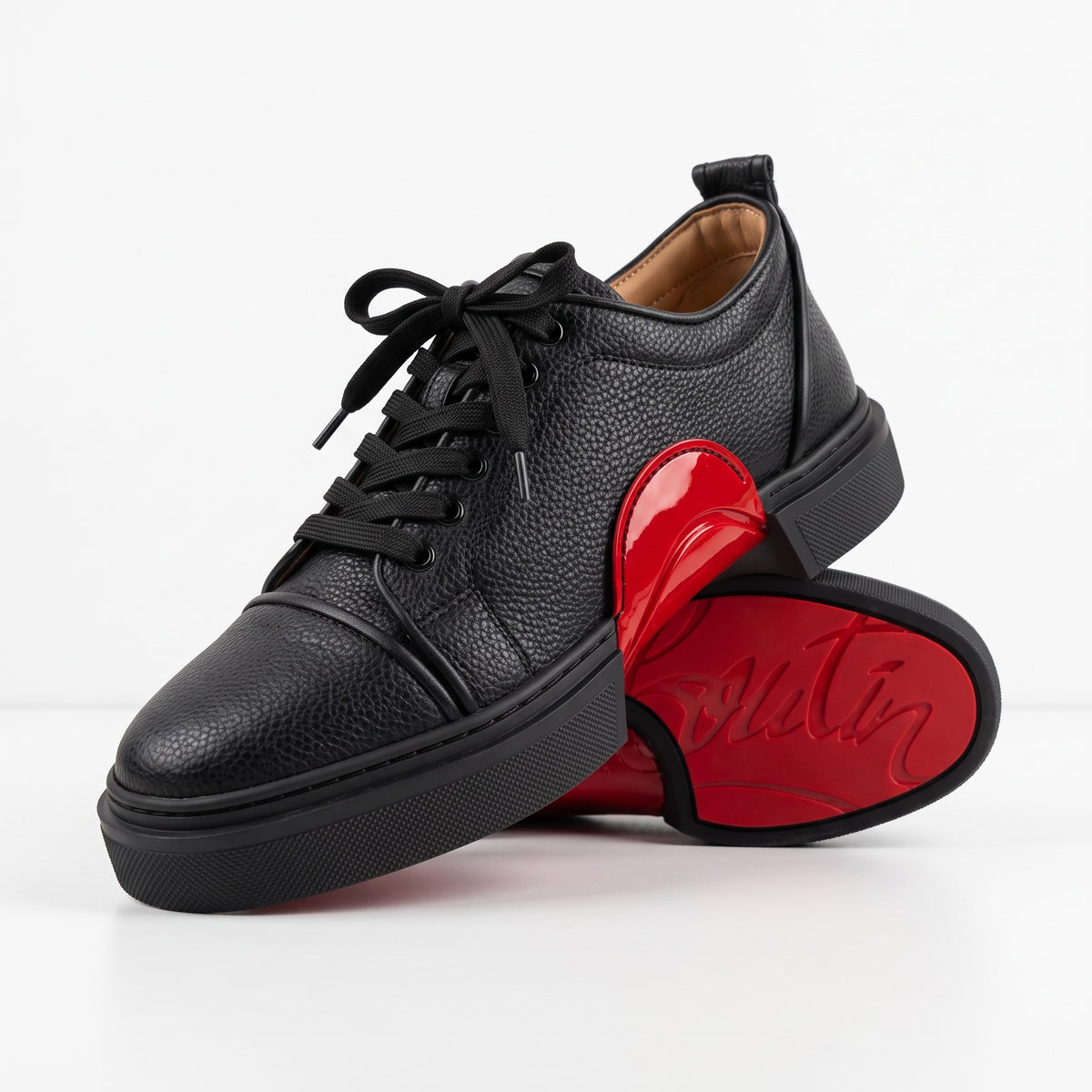 black low-top leather sneakers with red sole and red midsole detail