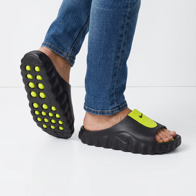 black Nike slide with volt green perforated strap and studded outsole