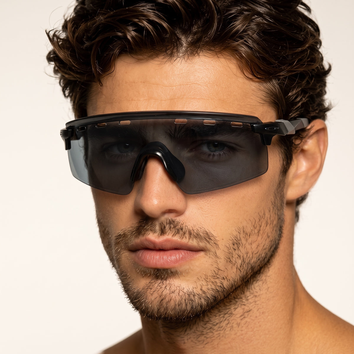 Close-up of man wearing black Oakley shield sunglasses with vented top and Oakley logo