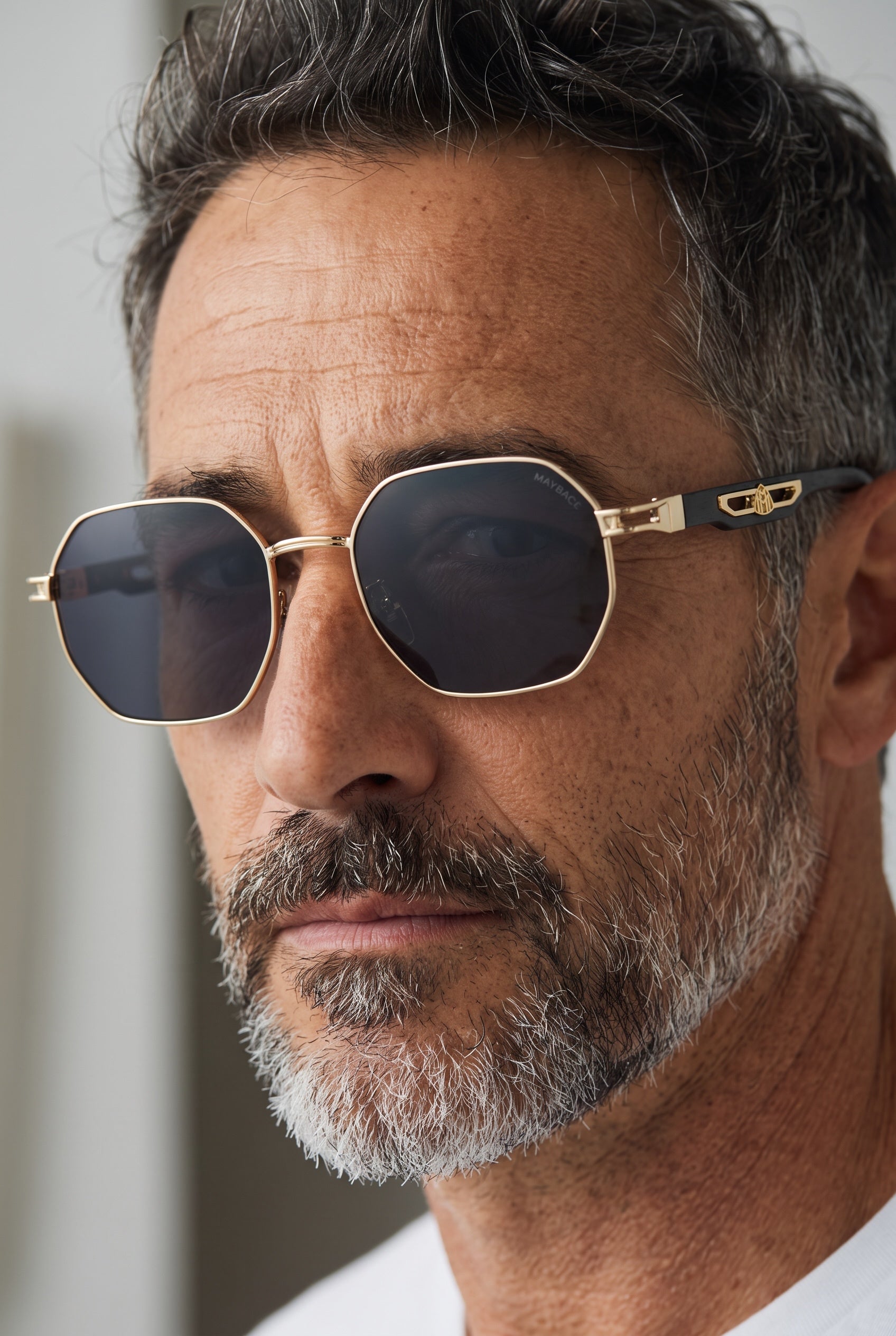 Maybach gold geometric frame sunglasses with dark lenses on man's face