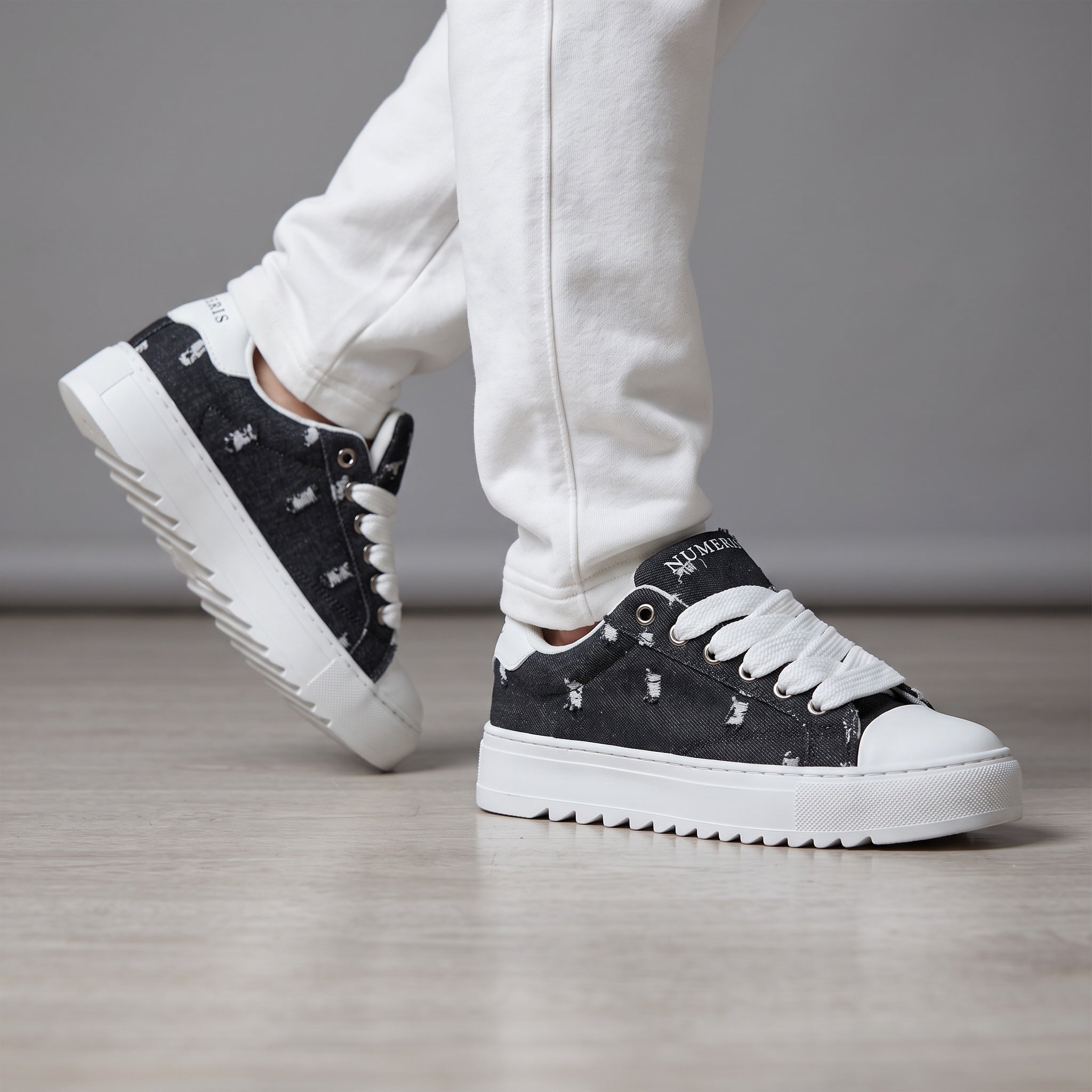 Numeris black distressed platform sneakers with white chunky sole and wide laces