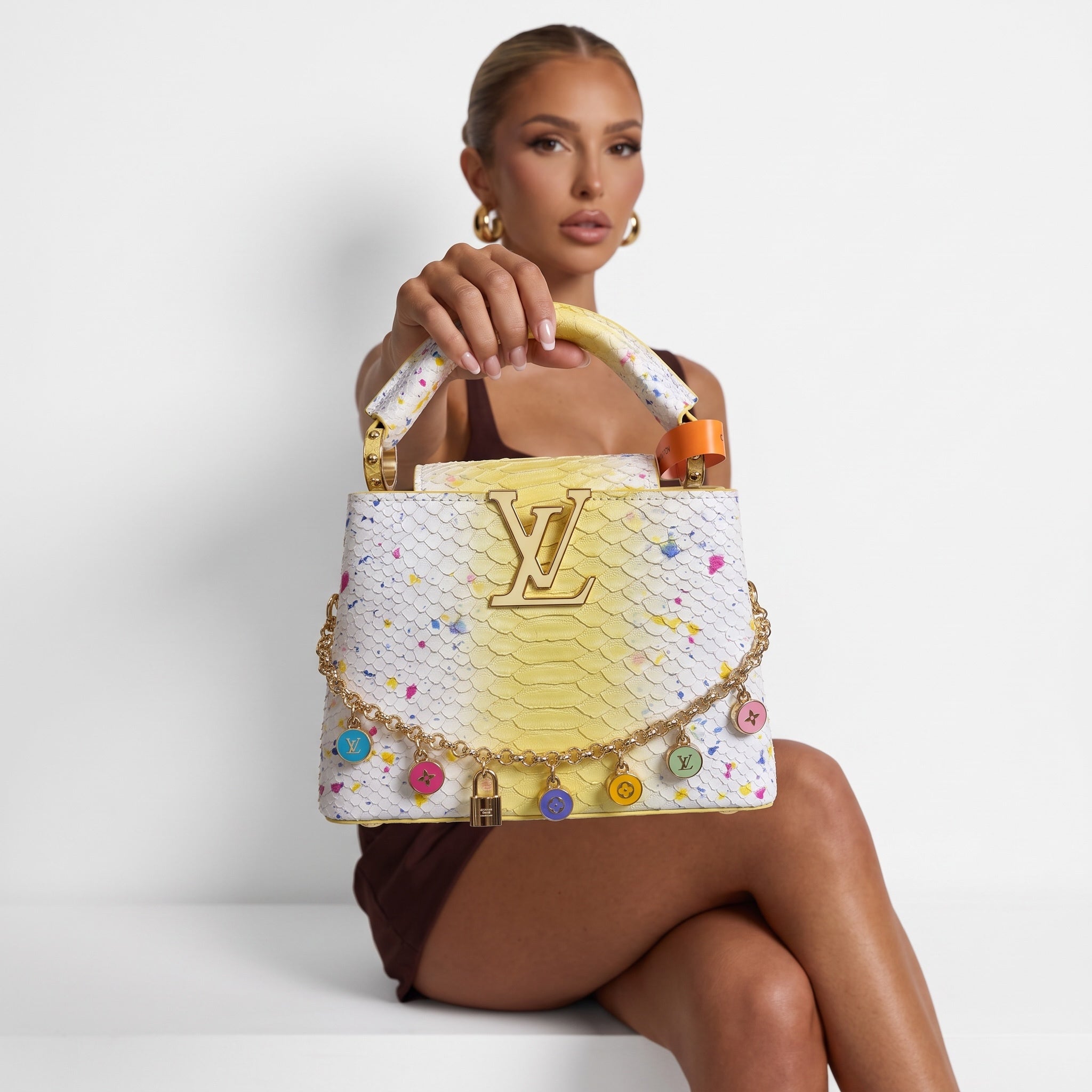 Yellow and white LV top-handle bag with colorful enamel charms and gold LV logo