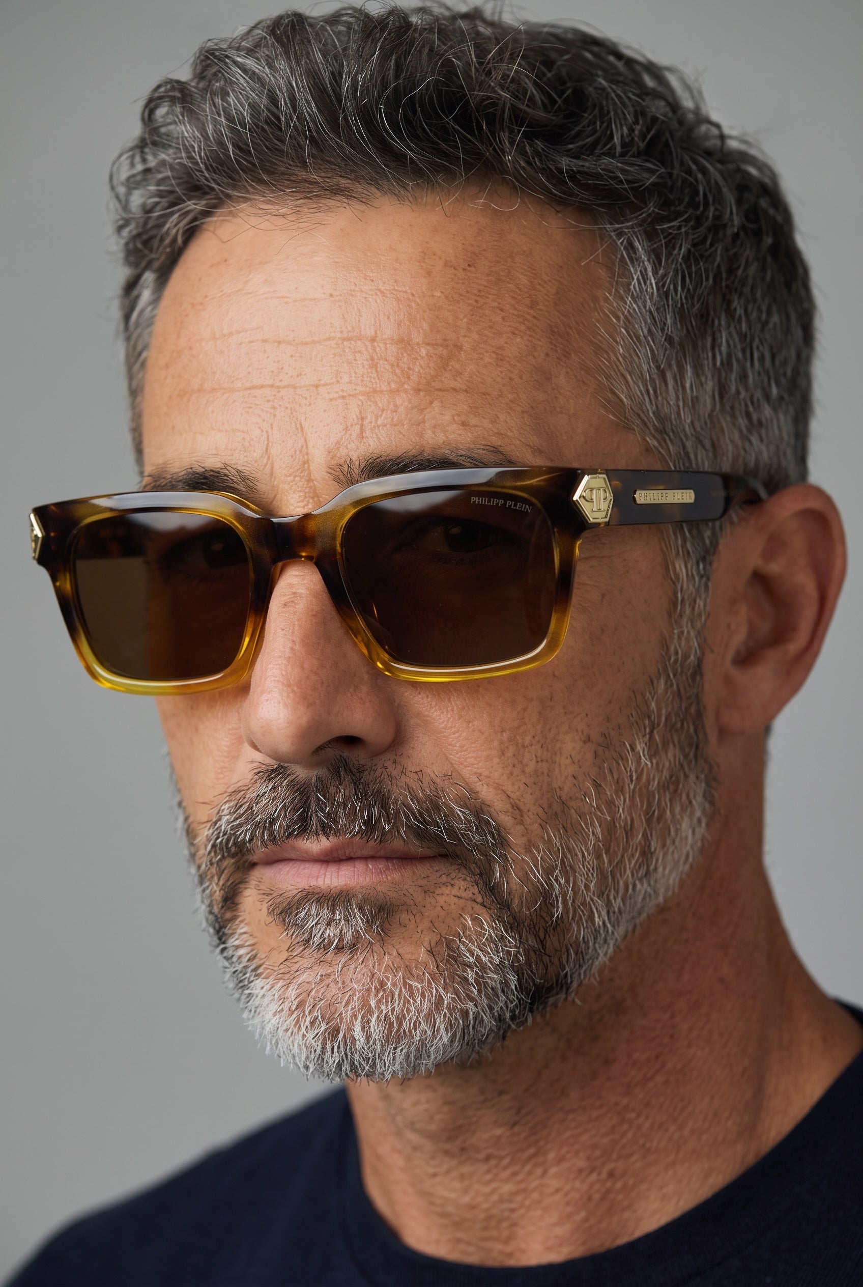 Philipp Plein tortoiseshell square sunglasses with brown lenses and gold logo hardware on a model