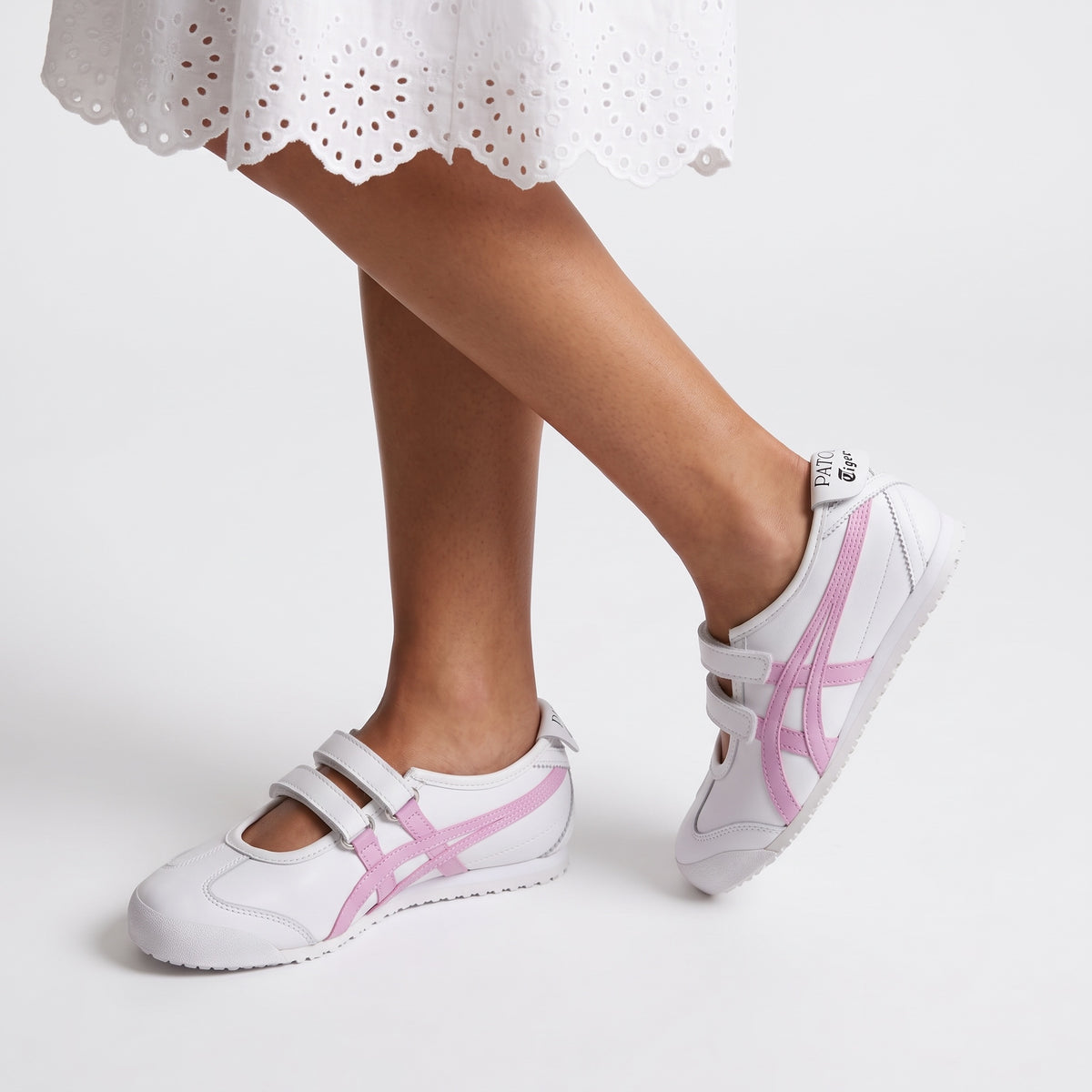 White Onitsuka Tiger trainers with pink side stripes and velcro straps