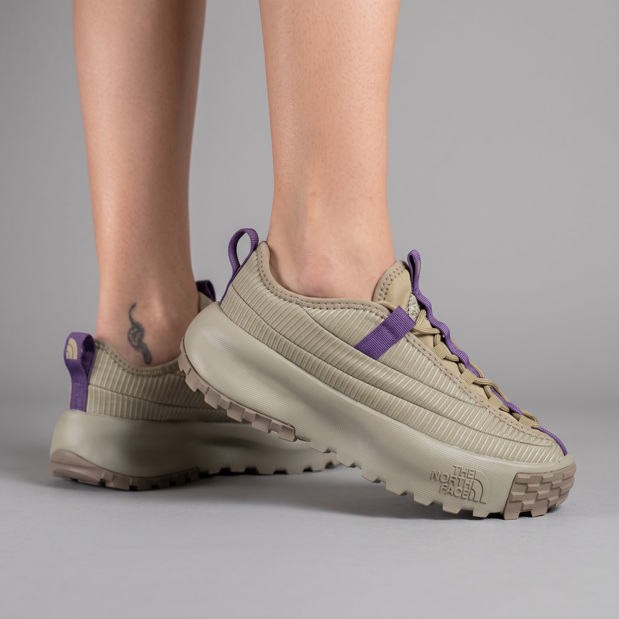 beige The North Face sneaker with purple webbing and chunky lug sole