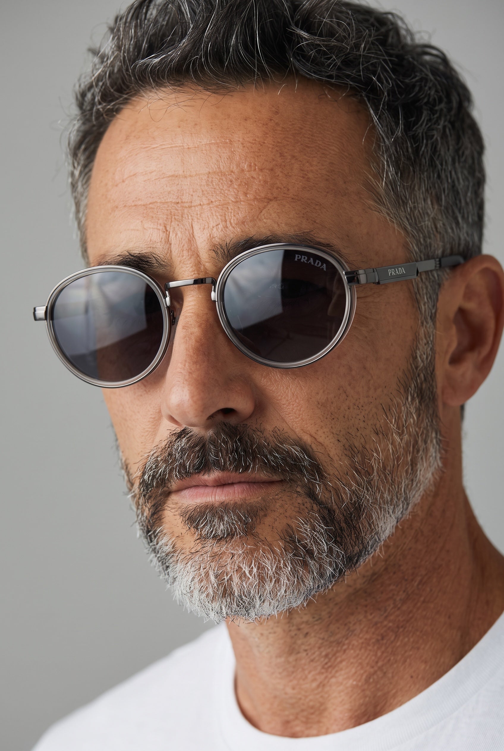 Close-up of man wearing Prada round gunmetal grey sunglasses