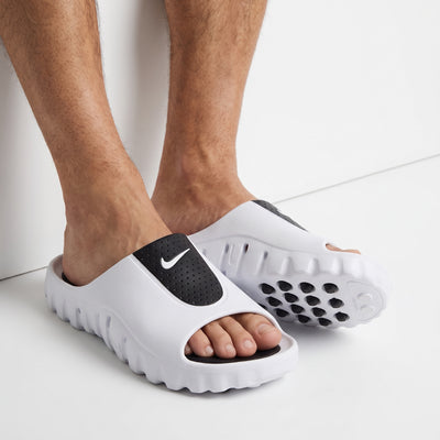 white Nike slip-on slide with black perforated strap and chunky textured sole
