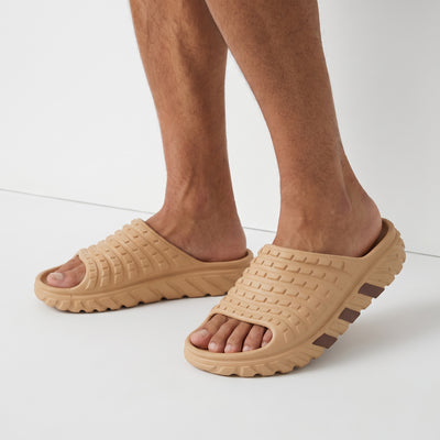 Beige chunky textured adidas-style slide sandal on foot
