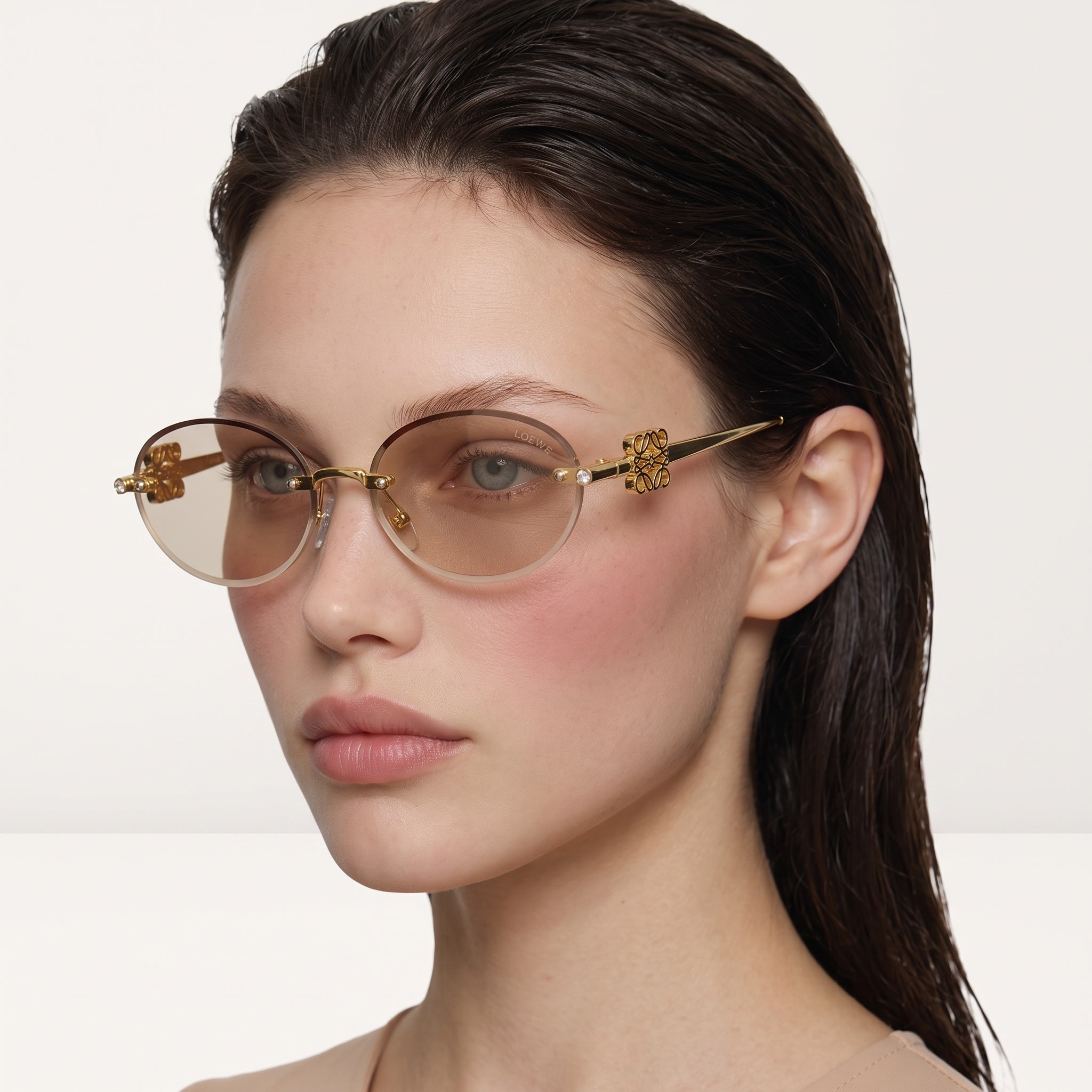 Loewe round gold sunglasses with gradient brown lenses and logo detail on temple