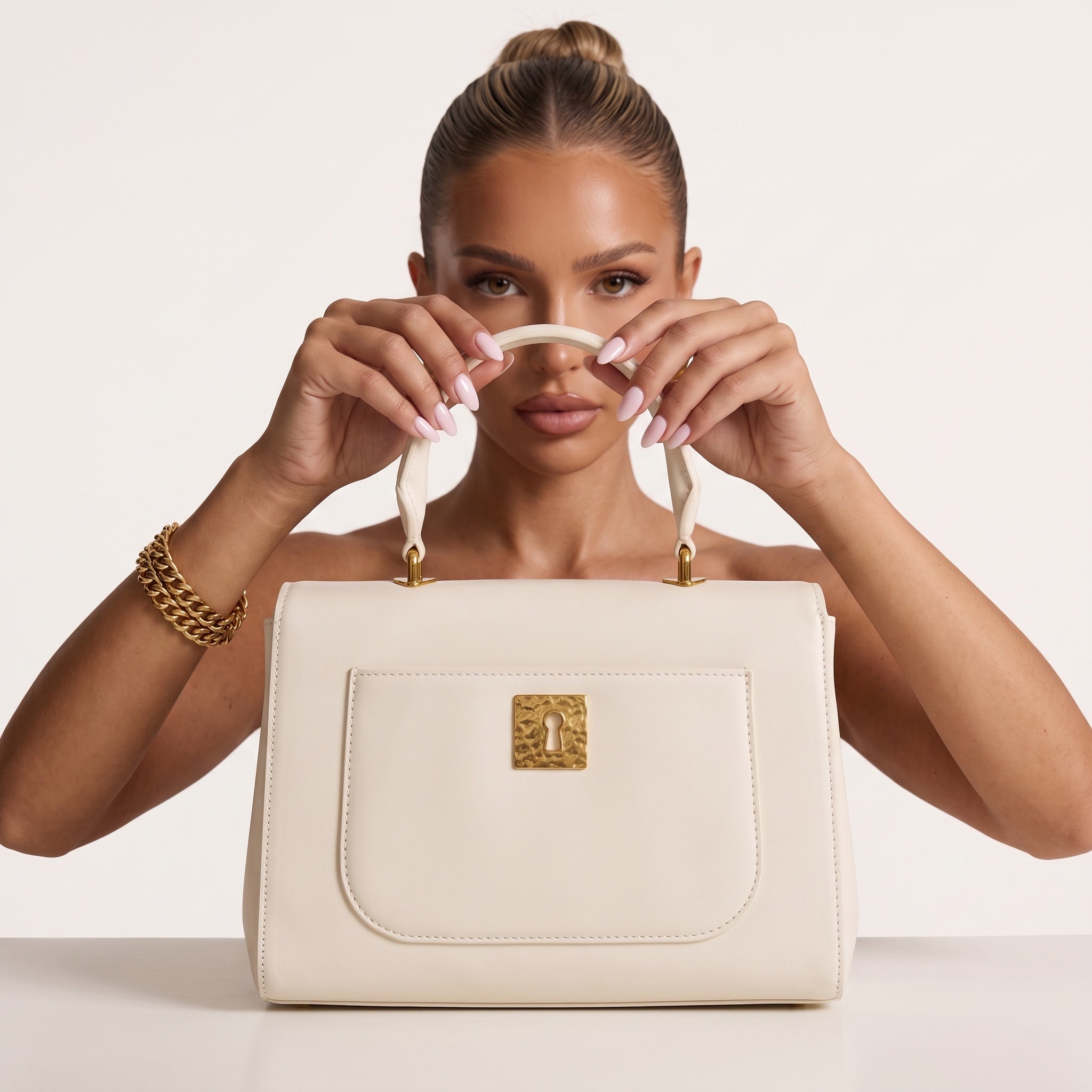 White top-handle bag with gold hardware and decorative charms