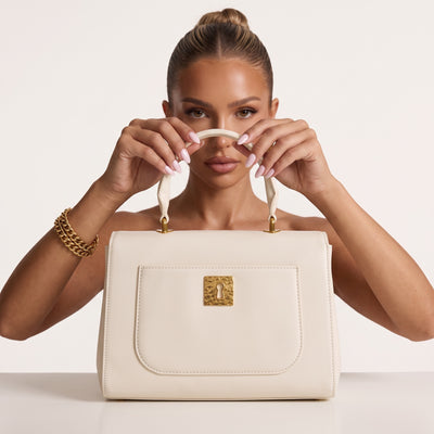White top-handle bag with gold hardware and decorative charms