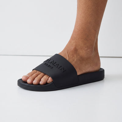 Black Balmain logo slide sandals on model feet