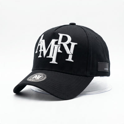 Black Amiri baseball cap with white embroidered logo and side patch.