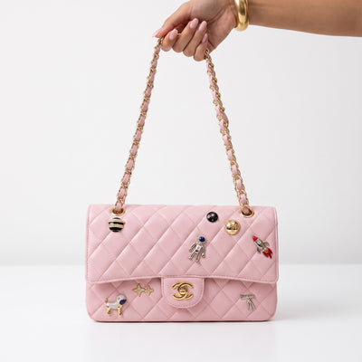 pink quilted Chanel flap bag with gold chain straps and charm pins
