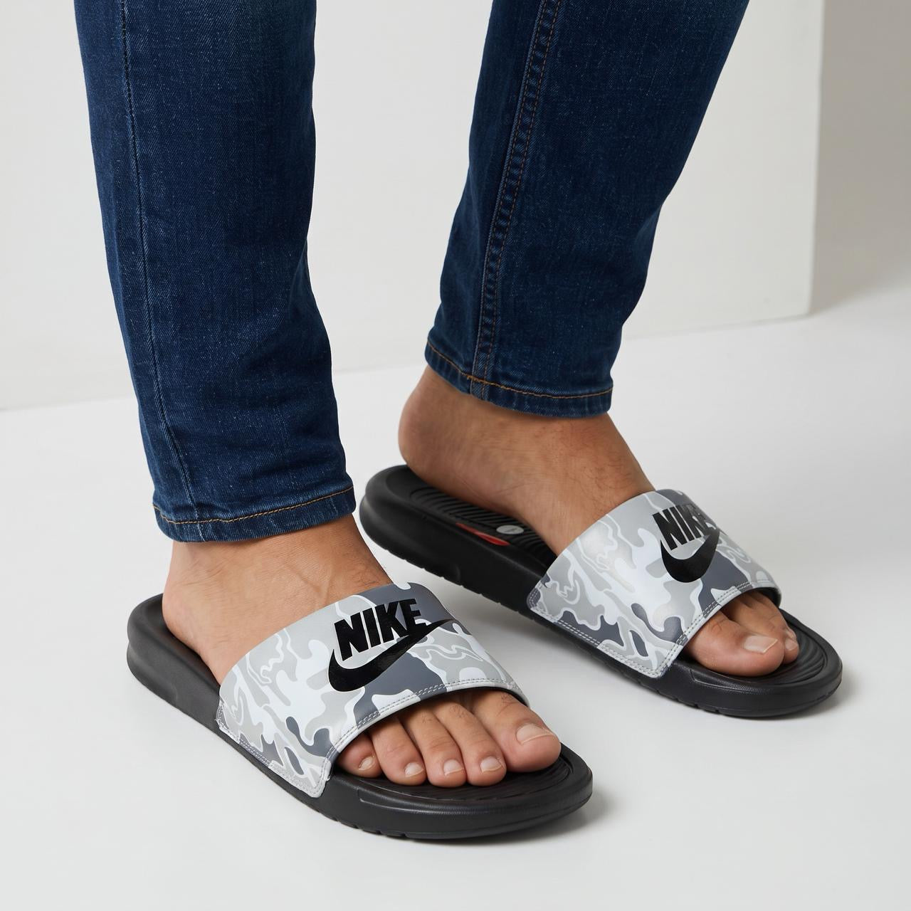 Nike grey camouflage slide sandals with black footbed and large black Nike logo