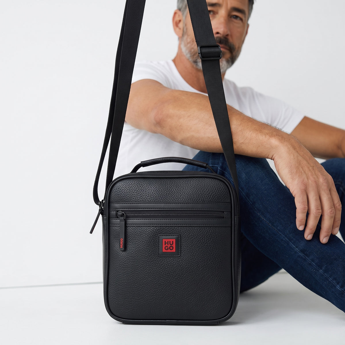 Black Hugo pebbled mini crossbody bag with front zip and adjustable strap