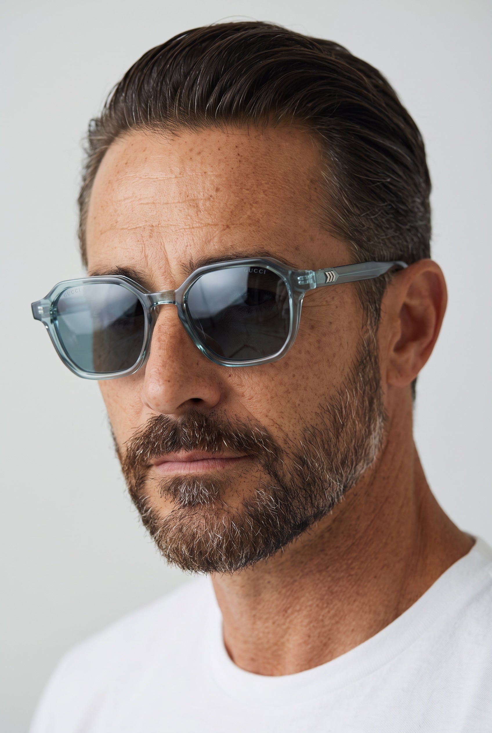 Translucent blue hex-shaped Gucci sunglasses with smoked lenses and chevron temple detail