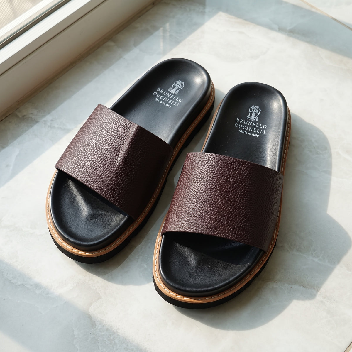 Brunello Cucinelli burgundy pebbled slide with black footbed and serrated sole
