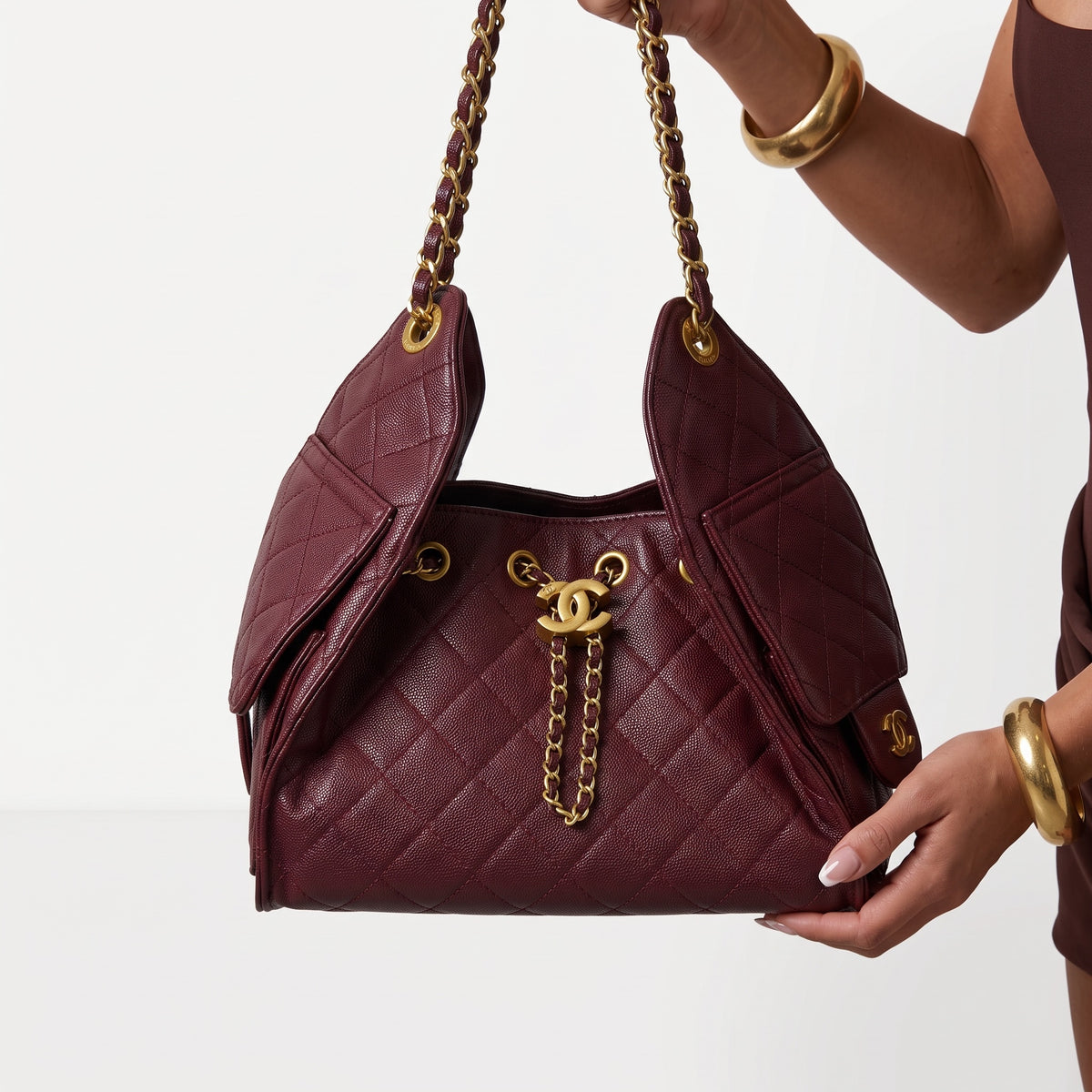 Burgundy quilted Chanel shoulder bag with gold chain handles and CC charm