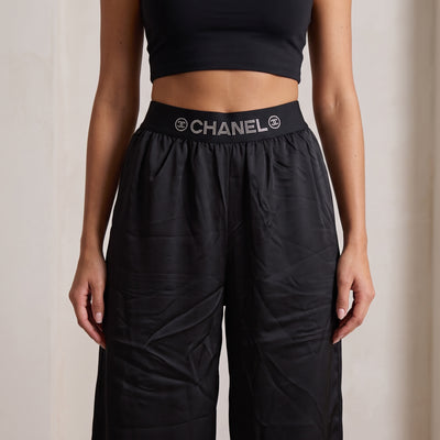 Black wide-leg trousers with high elastic waistband printed CHANEL logo in crystal dots