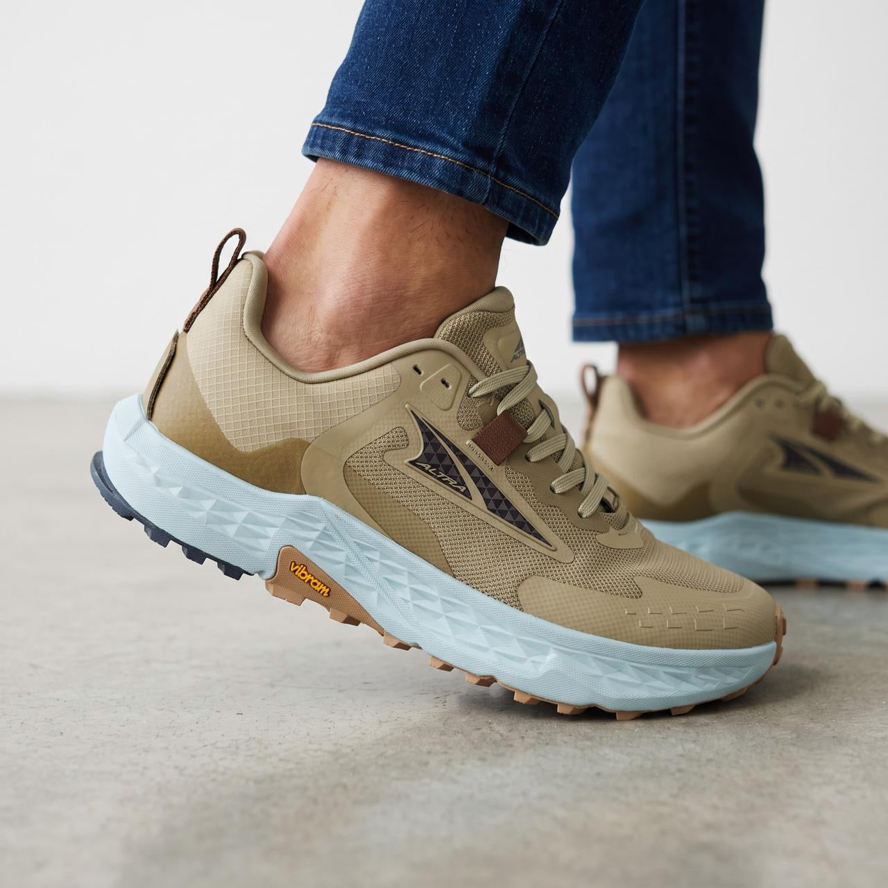 Altra tan trail running shoe with light blue midsole and Vibram sole