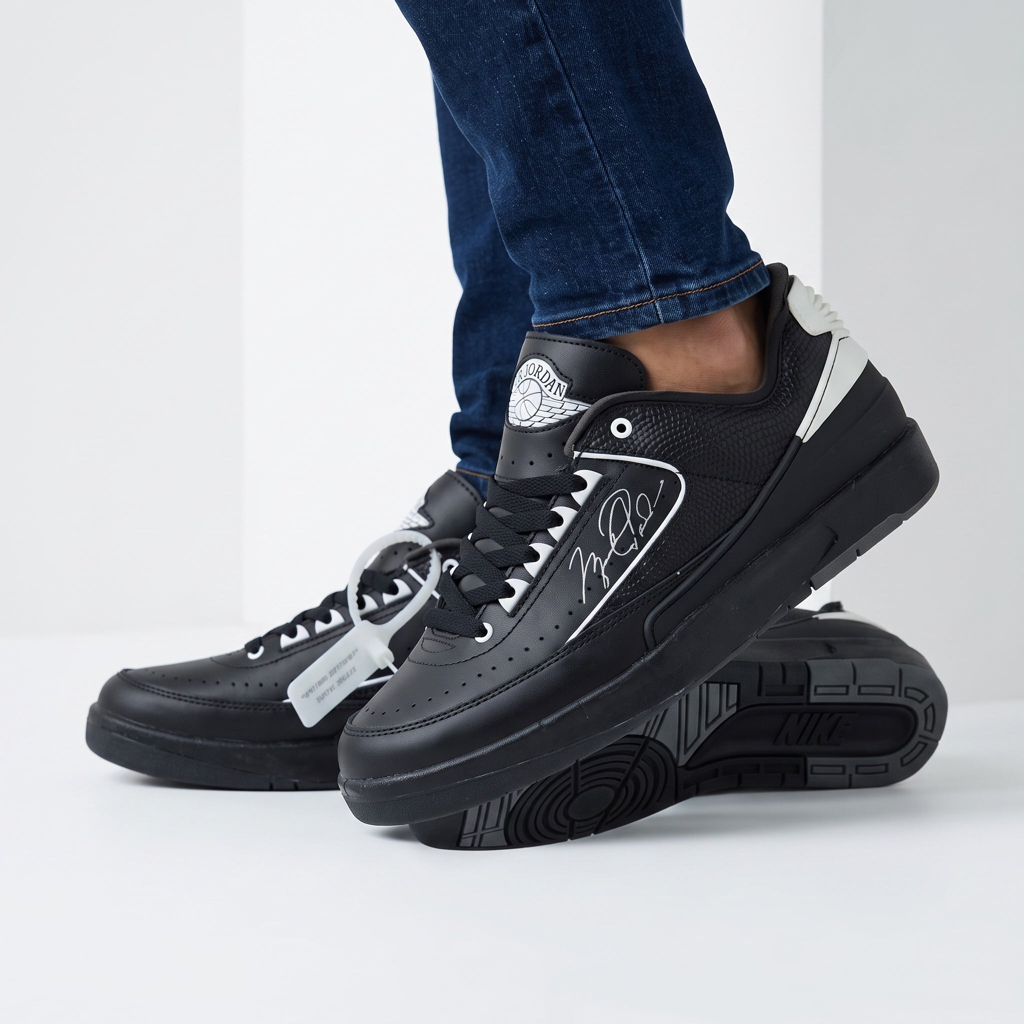Black Jordan low-top trainers with white accents and signature side graphic