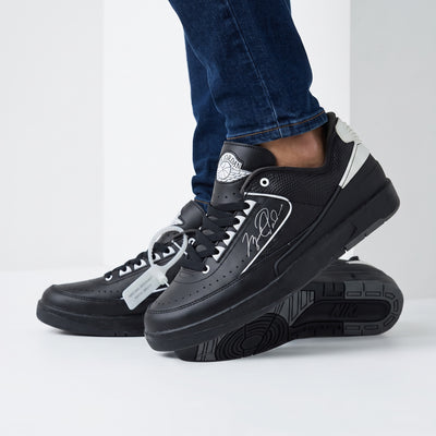 Black Jordan low-top trainers with white accents and signature side graphic