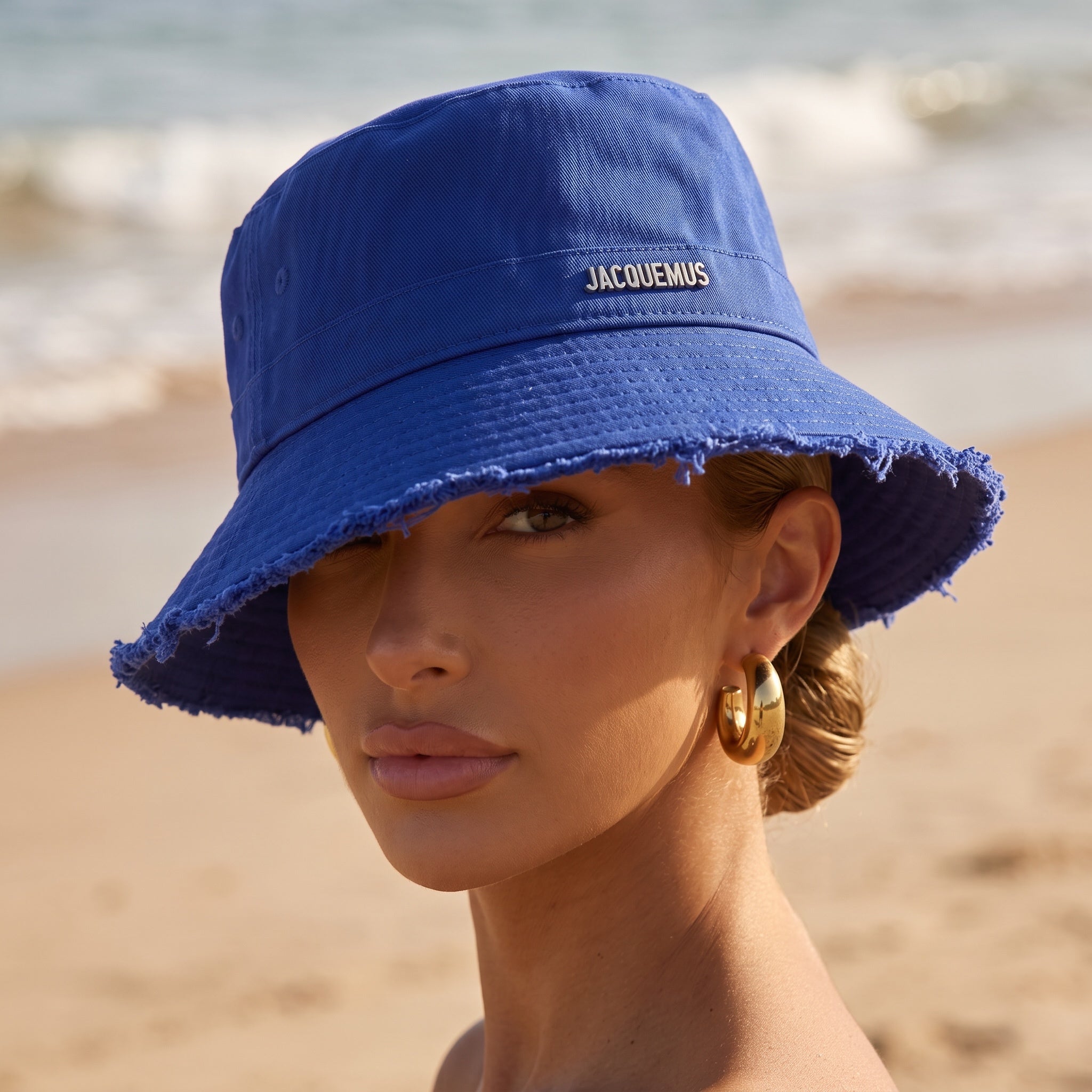 Royal blue Jacquemus bucket hat with frayed brim and logo plaque