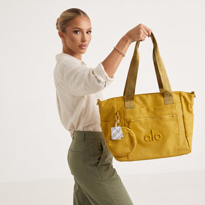 Mustard Alo tote bag with logo webbing straps and attached round pouch