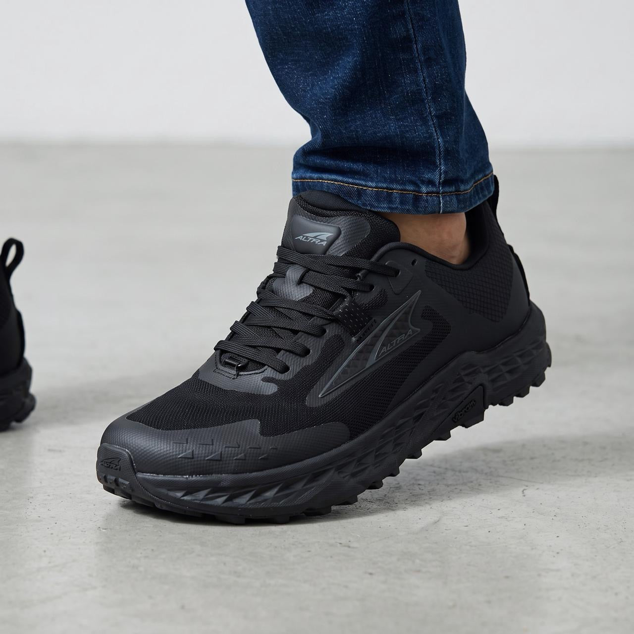 Altra black trail running shoes with Vibram outsole shown on feet