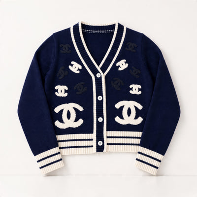 Navy Chanel cardigan with ivory trim and repeated CC logos, ribbed cuffs and hem, button front.