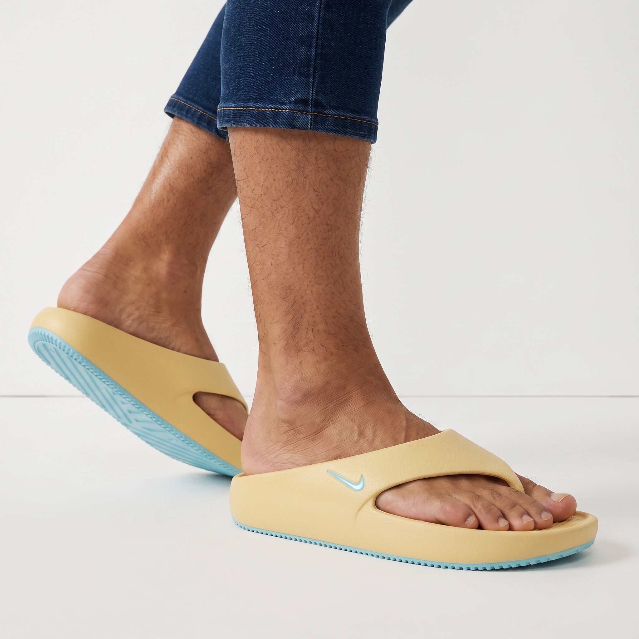 Nike pale yellow slides with aqua sole on model feet