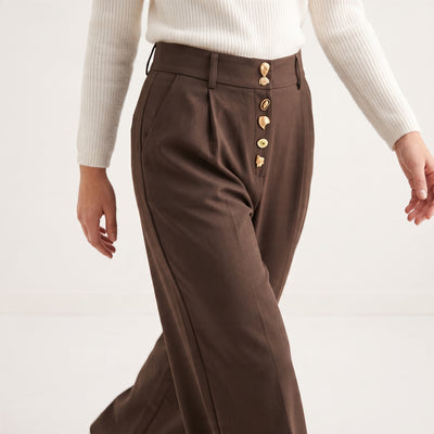 Brown high-waist trousers with gold decorative buttons down the front