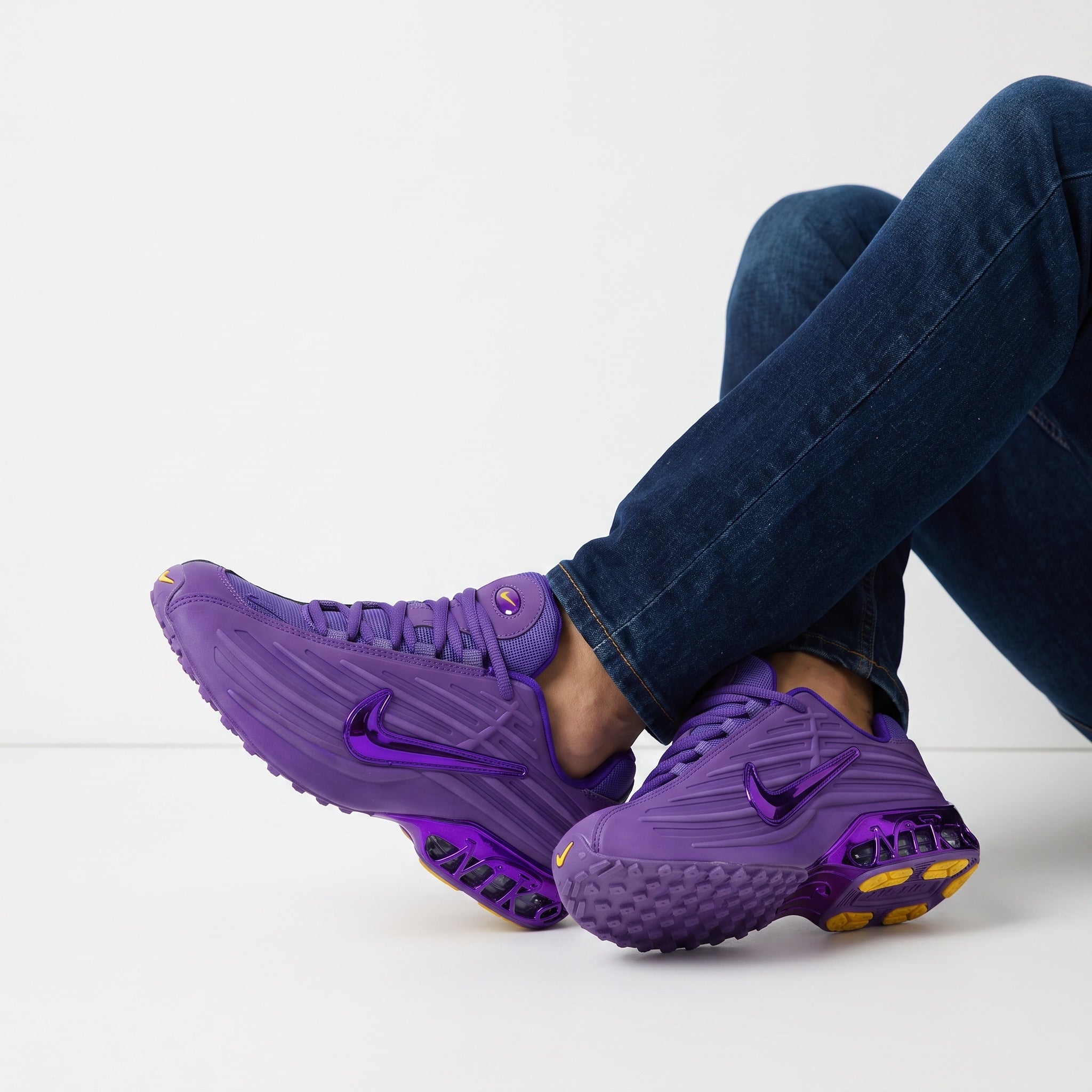 Pair of bright purple Nike sneakers with visible rear cushioning and glossy swoosh