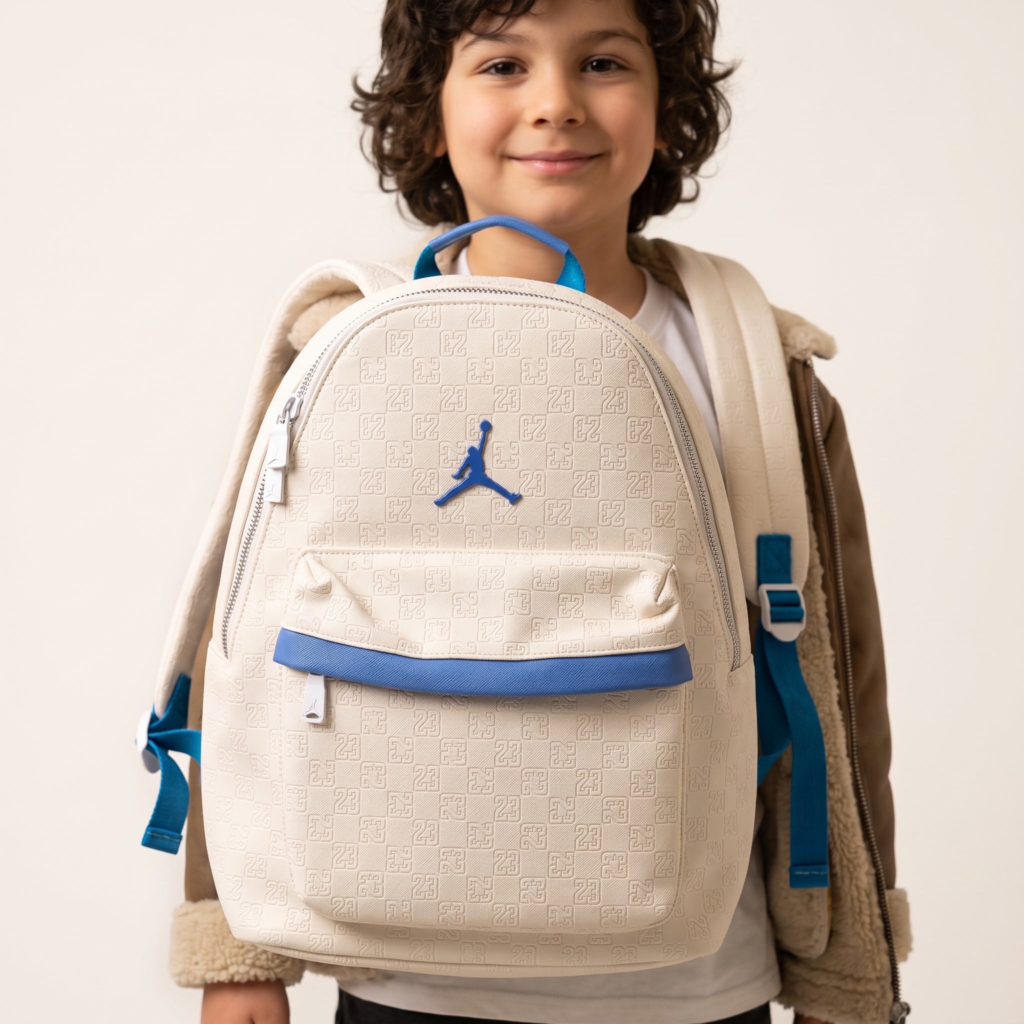 Cream Jordan backpack with embossed 23 pattern and blue trim